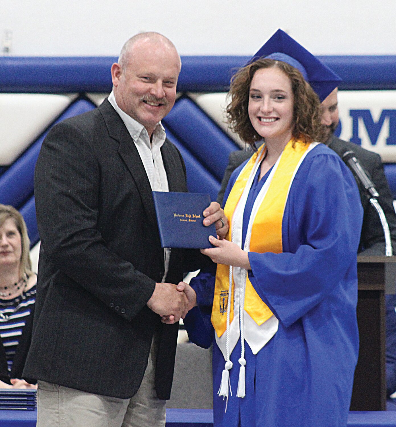 Norwood graduate Annie Sullivan receives her diploma from her father and school board member, Chad Sullivan.
